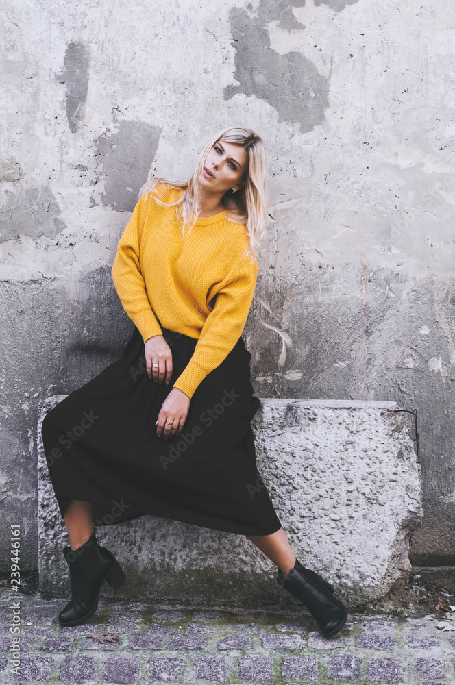 yellow sweater, wearing a black skirt 