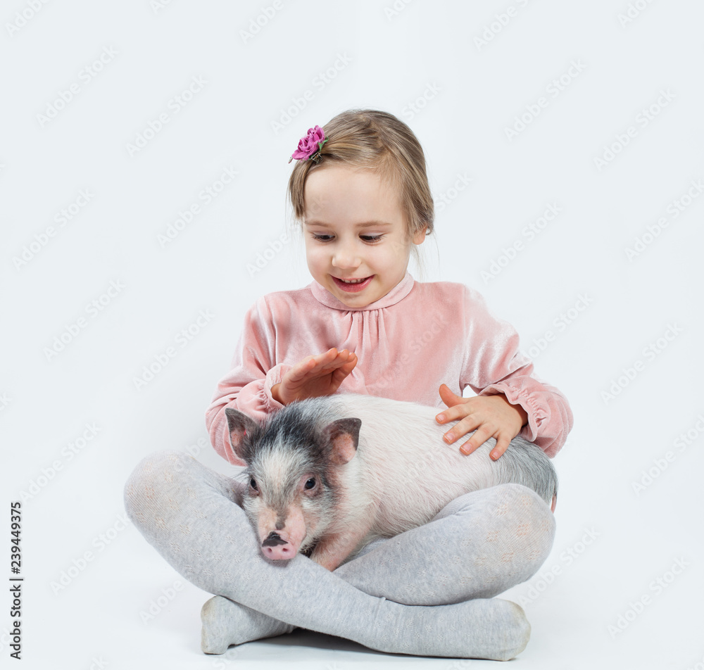 Happy child girl with pig. Child and pet Happy child girl with pig. Child and pet