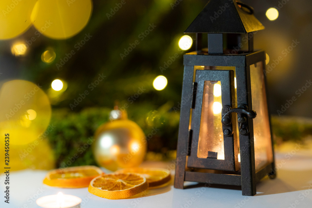 a lantern surrounded by christmas decoration and christmas string lights in an natural enviroment