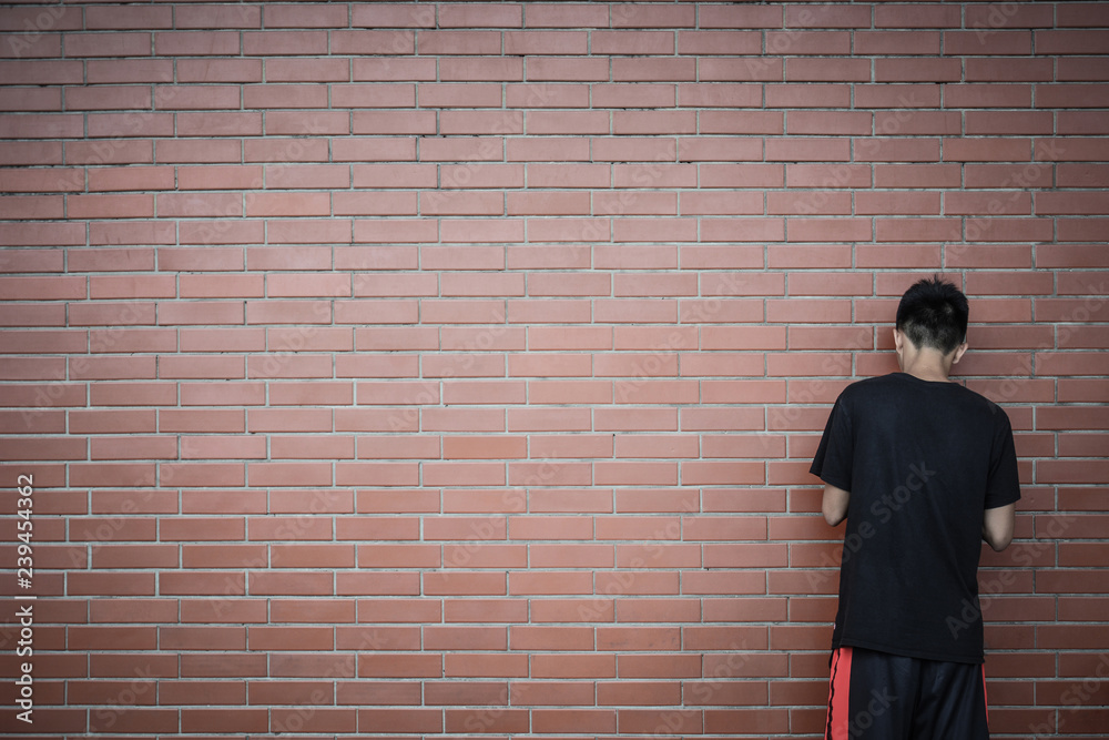 back view of teenage Asian boy standing in front of red brick wall  background, copy space, teenager problem concept Stock Photo | Adobe Stock