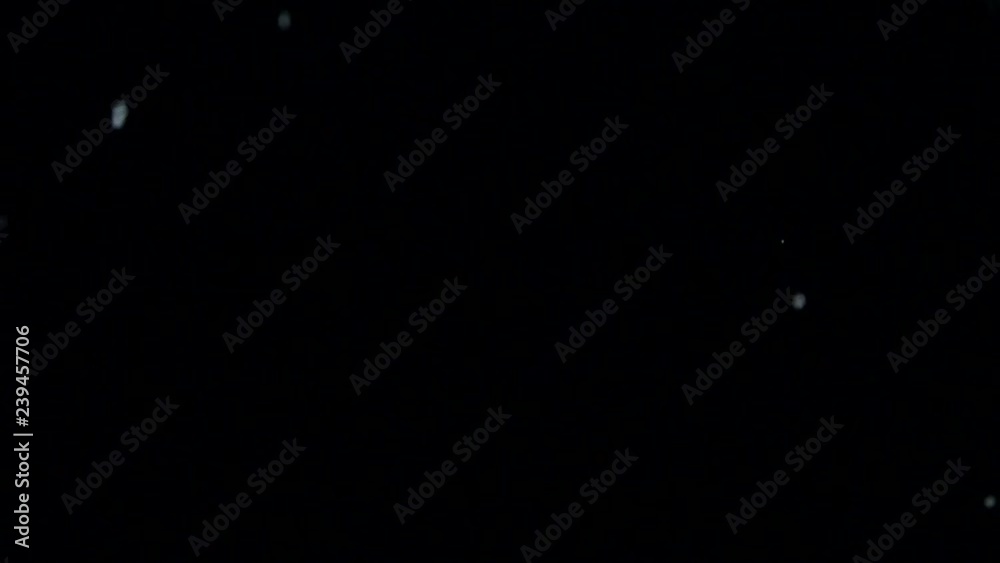 Crystals of salt falling down or thrown up on the black background Crystals of salt falling down or thrown up on the black background