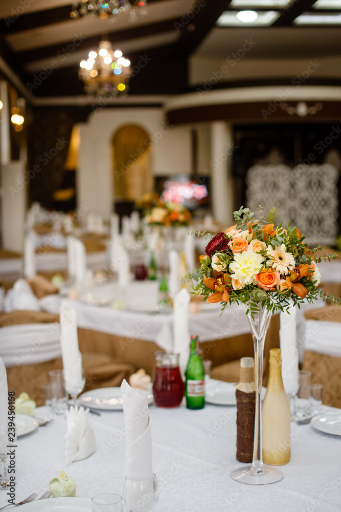 wedding decor on tables in restaraunt, a bouquet of flowers with a glass vase wedding decor on tables in restaraunt, a bouquet of flowers with a glass vase