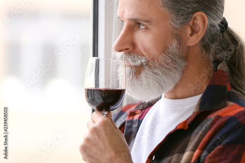 Senior man drinking wine ne...