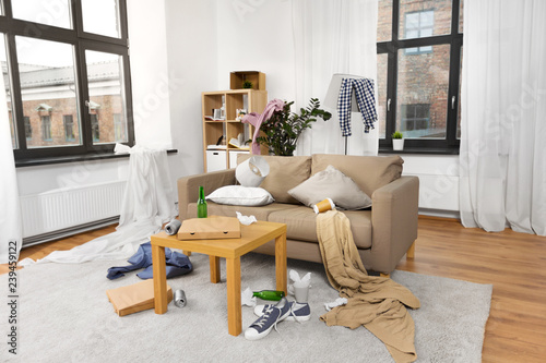 mess, disorder and interior concept - view of messy home living room with scattered stuff photo