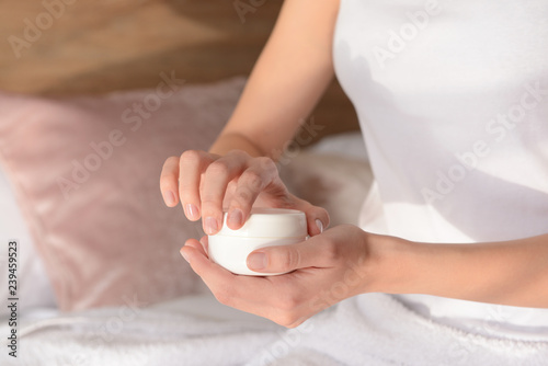 Woman with jar of cream at home