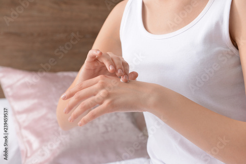 Woman applying hand cream at home