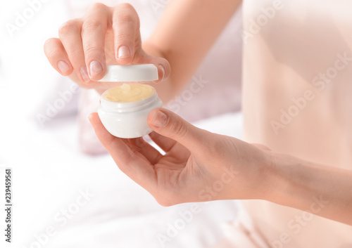 Woman with jar of cream at home, closeup