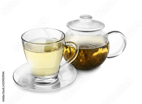 Teapot and cup of hot beverage on white background