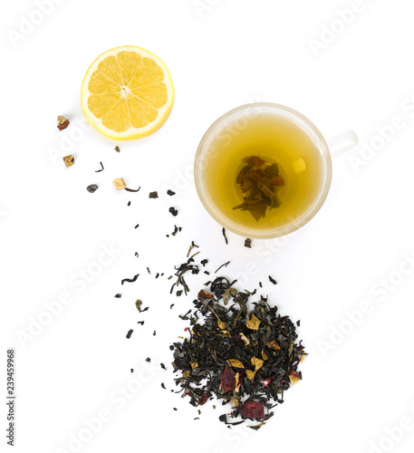 Cup of hot tea, dry leaves and lemon on white background