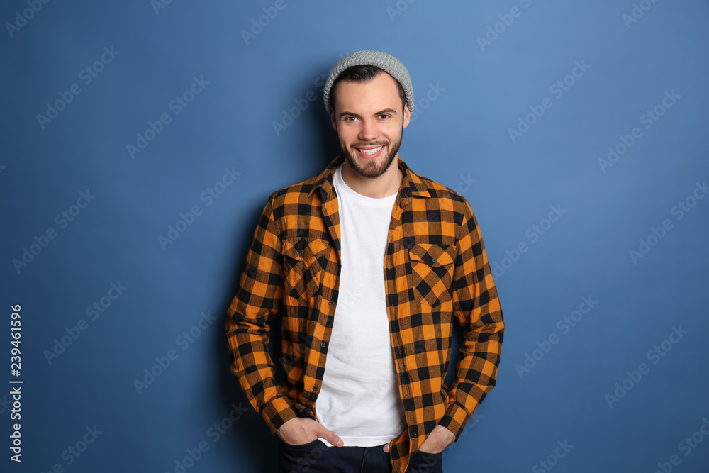 Fashionable young man in checkered shirt on color background