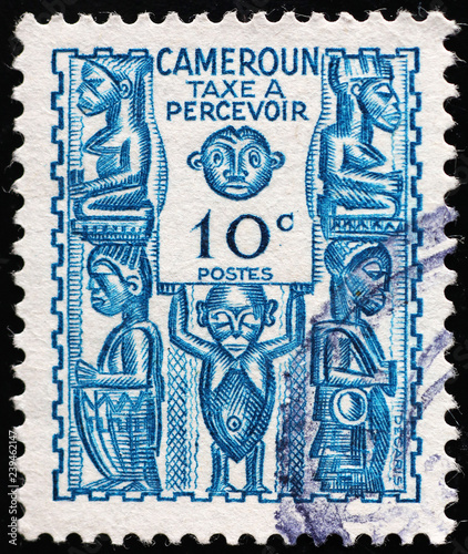 Wooden statuettes on vintage postage stamp of Cameroon