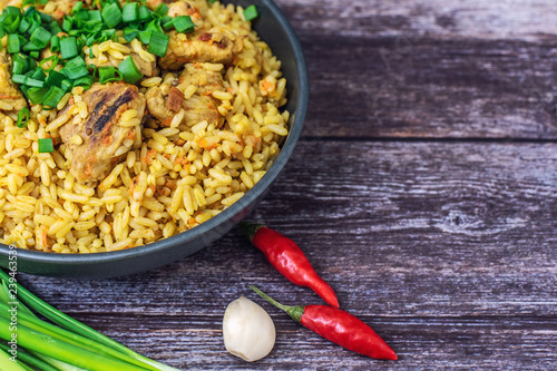 Rice pilaf with meat carrot and onion on wooden background