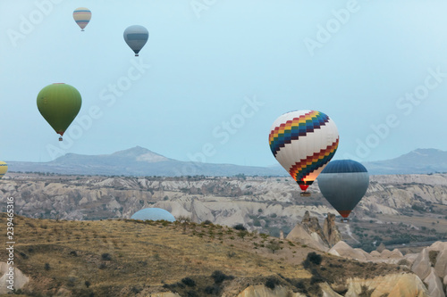 Colorful Hot Air Balloons Flying In Sky Above Rock Valley