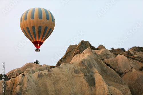 Hot Air Balloon Flying In Beautiful Nature Landscape With Rocks