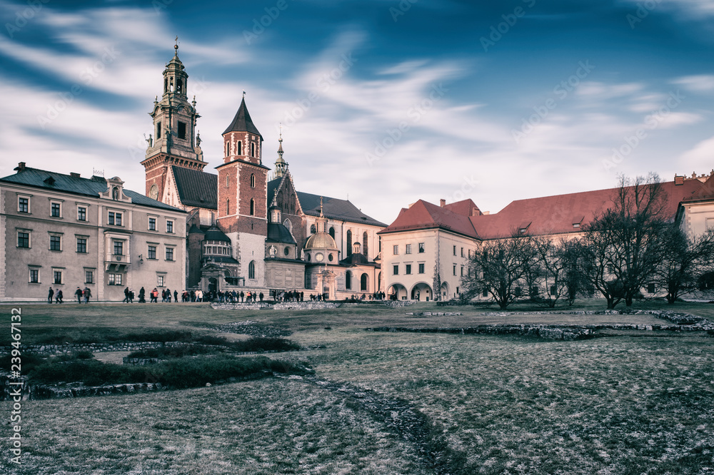 Wawel royal castle in Krakow, medieval fortress, stunning architectural ensemble on the Wawel hill, vintage image with dramatic cloudy sky, travel outdoor background, Poland, Europe