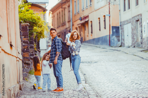 Lovely family of travelers standing on the ancient street