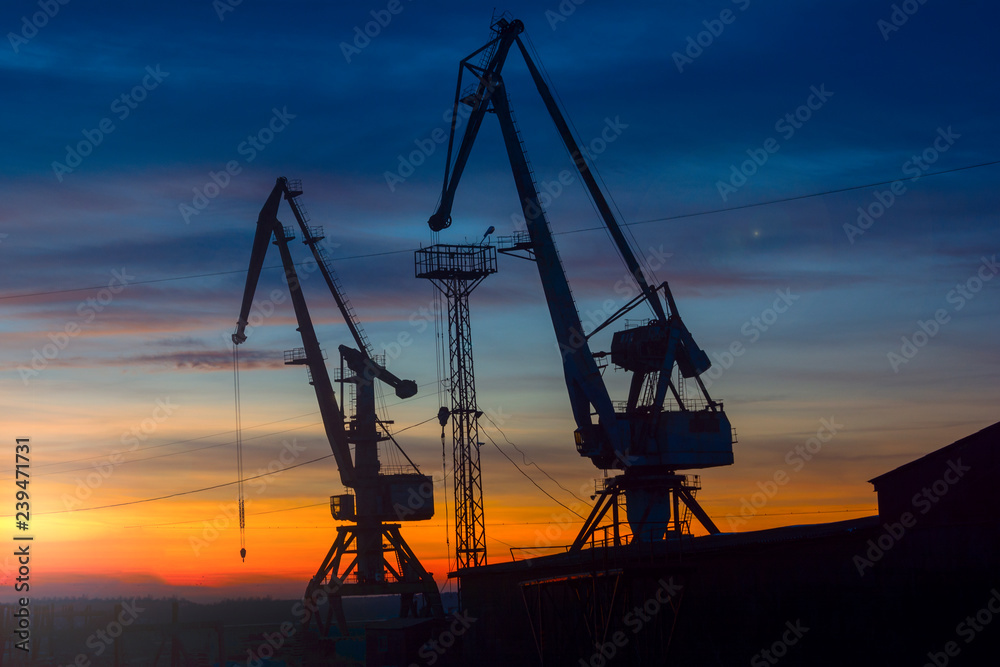 port cranes on the background of sunset. soft focus