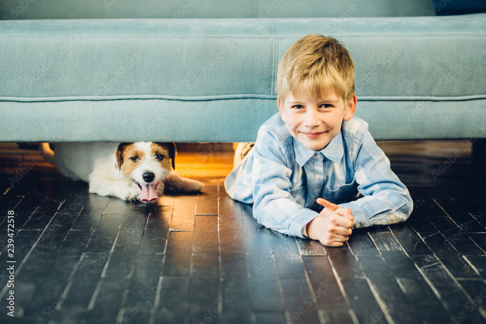 © Iryna - Little blond boy playing with his dog at home. Friendship dog and child conept.