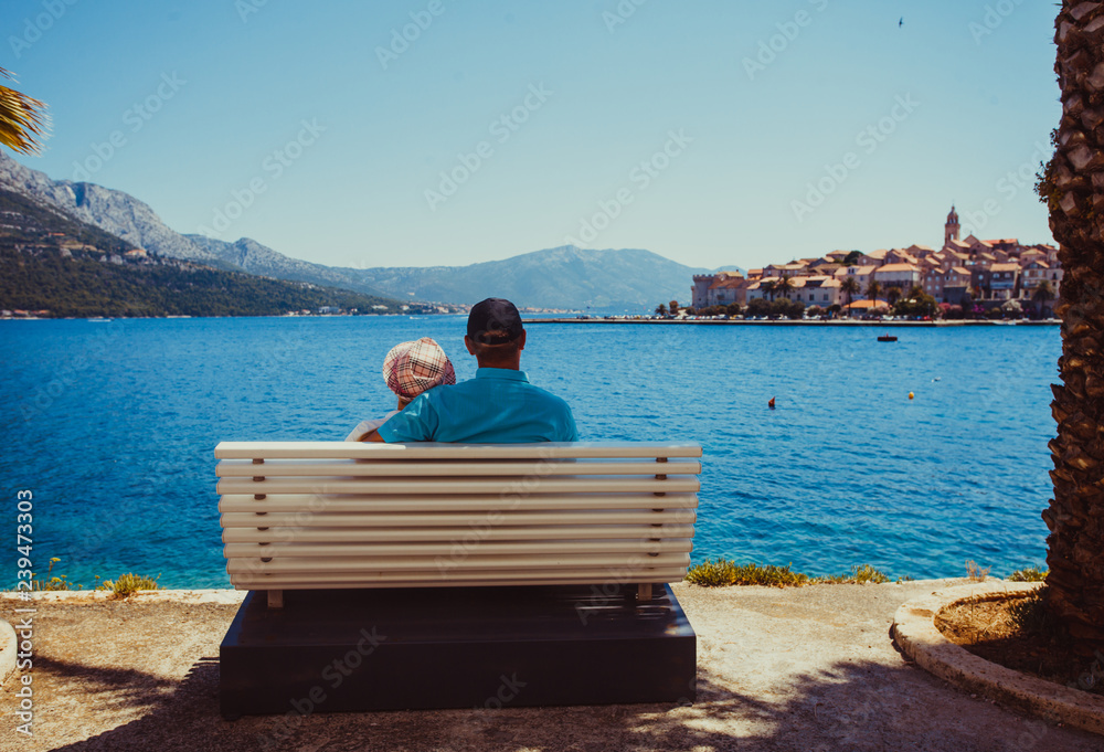 Sweet married couple sitting on a bench near the sea