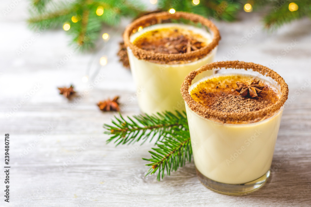 Homemade eggnog in glasses on wooden table surface Homemade eggnog in glasses on wooden table surface