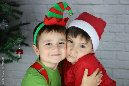 niños felices abrazados en navidad disfrazados de duende y Santa Claus ...