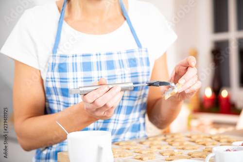 junge blonde Frau backt in der Küche Pläzchen Keckse für Weihnachten