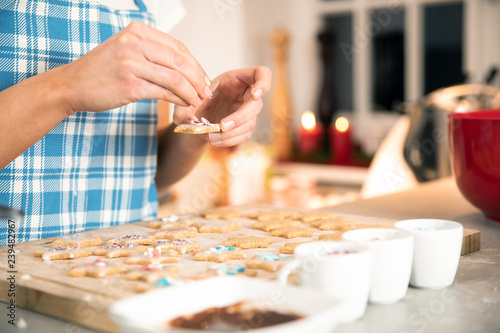 young beautiful woman is baking coockies in the kitchen for christmas xmas