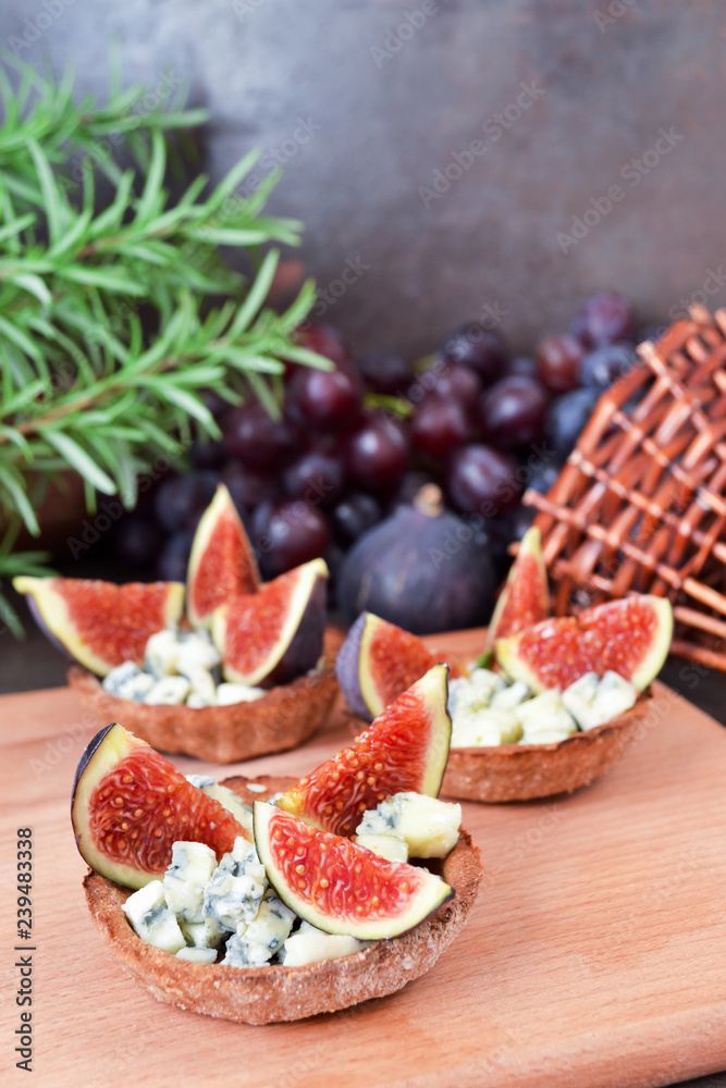 Festive appetizer. Rye flour tarts with gorgonzola cheese, fig fruit slices and honey. Healthy food concept. Perfect combination of cheese, fruits and honey syrup. Festive appetizer. Rye flour tarts with gorgonzola cheese, fig fruit slices and honey. Healthy food concept. Perfect combination of cheese, fruits and honey syrup.