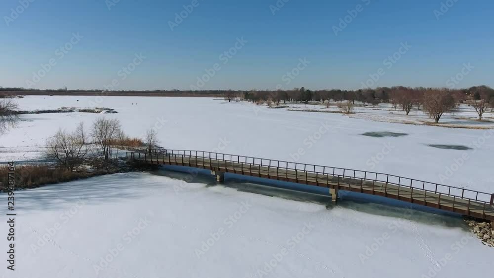 Aerial view forward over bridge winter snow lake Aerial view forward over bridge winter snow lake