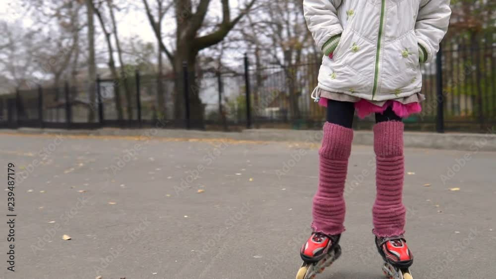 girl ride in autumn park on rollerblades, sport and recreations. girl ride in autumn park on rollerblades, sport and recreations.