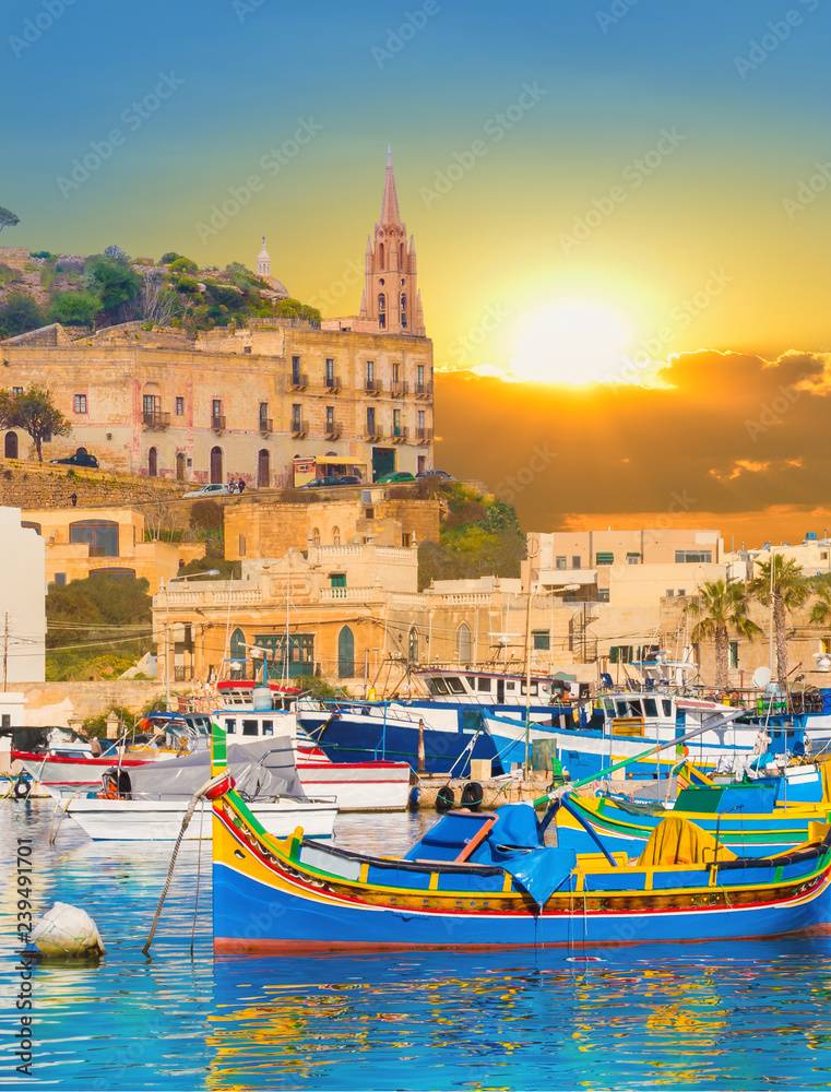 Marsaxlokk village harbor of Malta, illuminate by sunset light