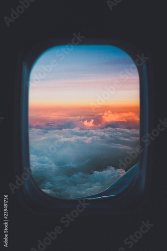 Colorful sunset sky through airplane window