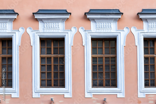 Vintage architecture pink classical facade. Wall with framed windows front view © orininskaya