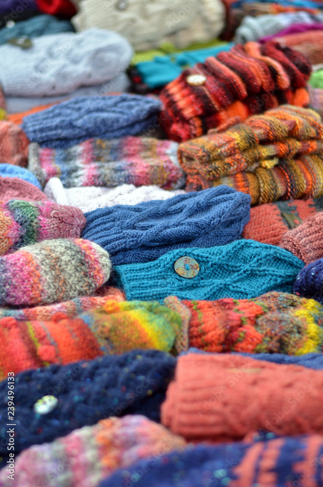 Viele bunte selbst gemachte Mützen und Handschuhe aus Wolle in einer Auslage