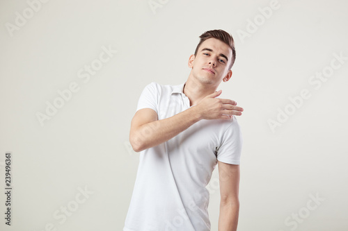 Valokuva Indifferent  guy dressed in a white t-shirt and jeans is on a white background i