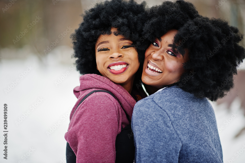 Two curly hair african american woman wear on sweaters posed at winter day. Two curly hair african american woman wear on sweaters posed at winter day.