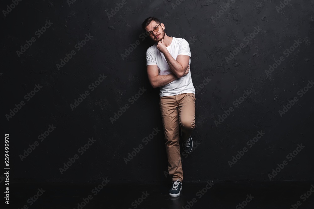 Full length portrait of happy handsome young man isolated on black background.