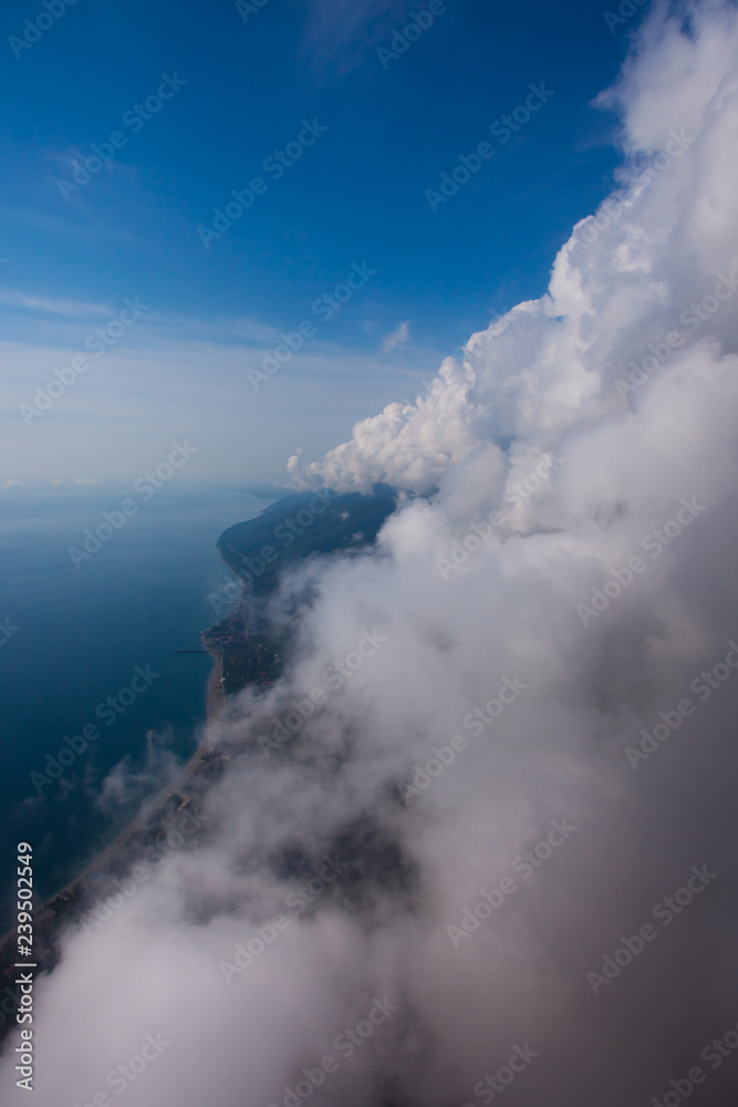 flight near the wall of clouds, free flight. Wall of clouds, blue sky and sea.
