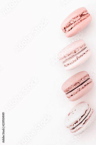 The vertical row of pastel macaroons on the light background. Copy space.