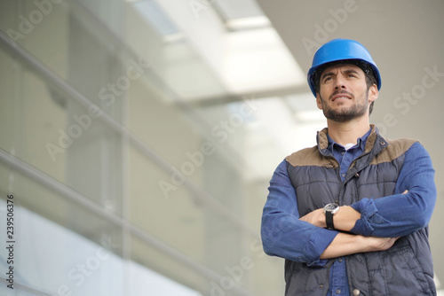 Industrial worker in hardhat infront of modern building photo