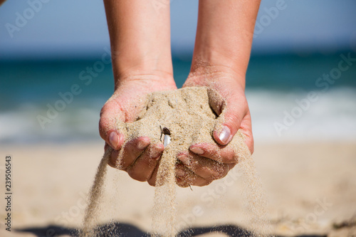 Hand holding sand. Hand with sand. Hand sand down gently on the beach 