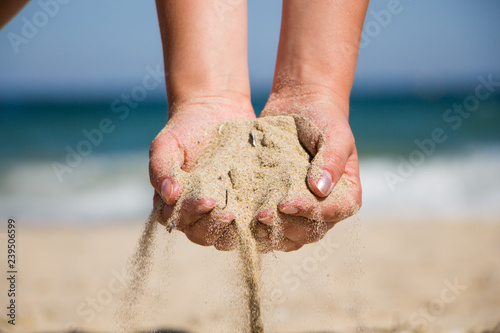Hand holding sand. Hand with sand. Hand sand down gently on the beach 