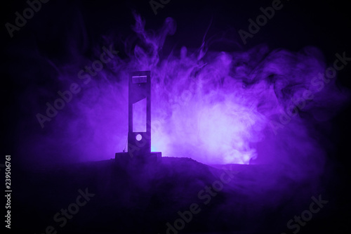 Horror view of Guillotine. Close-up of a guillotine on a dark foggy background. photo