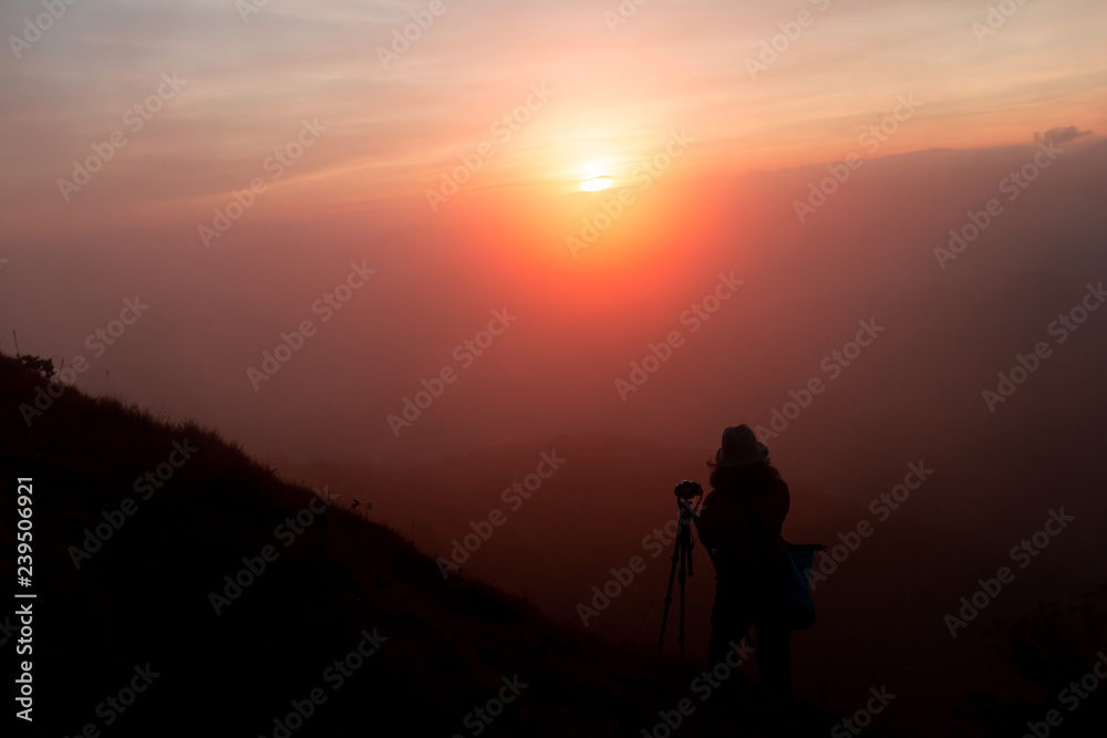 tourist Take a photo at the top of the mountain During sunset

