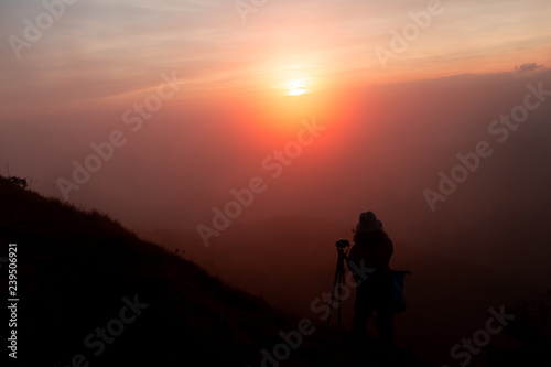 tourist Take a photo at the top of the mountain During sunset 
