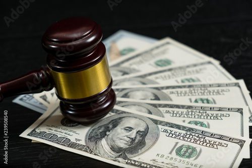 Judge's gavel on the background of dollar bills