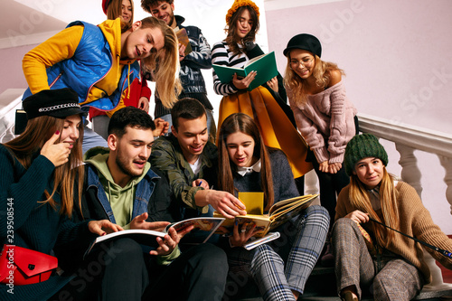The group of cheerful students sitting in a lecture hall before lesson. The education, university, lecture, people, institute, college, studying, friendship and communication concept
