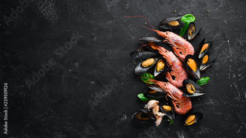 Cooked mussels and shrimp. Top view. Free space for your text. On the old background.