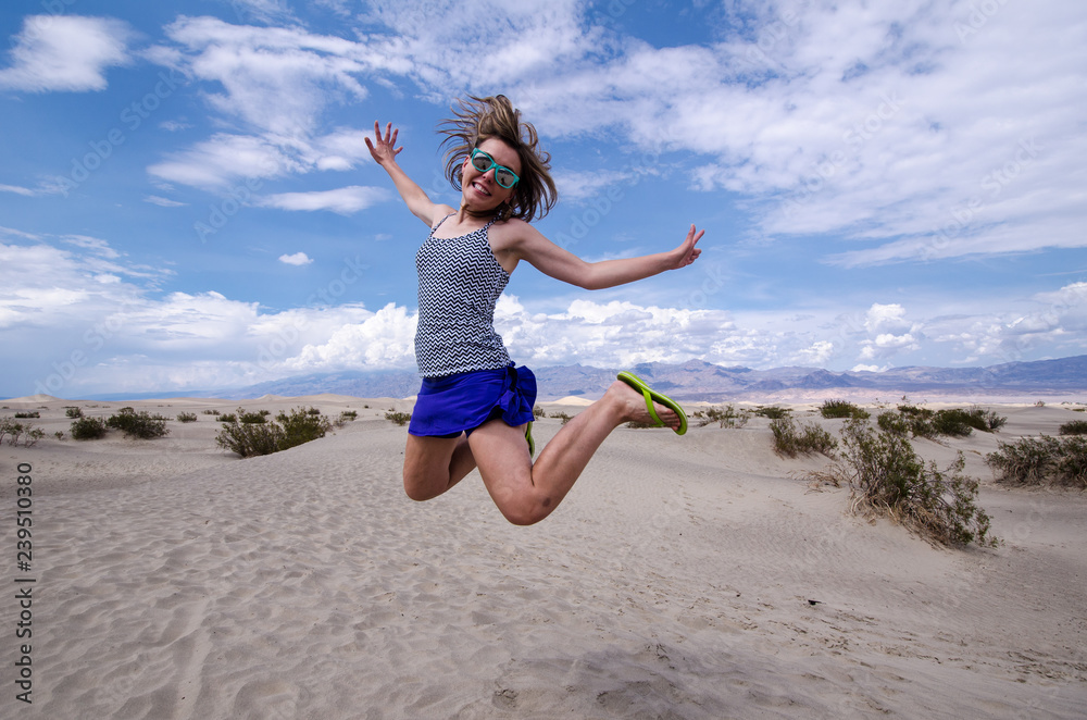 Young adult female woman jumps in the Mesquite Sand Dunes in Death Valley National Park in California Young adult female woman jumps in the Mesquite Sand Dunes in Death Valley National Park in California