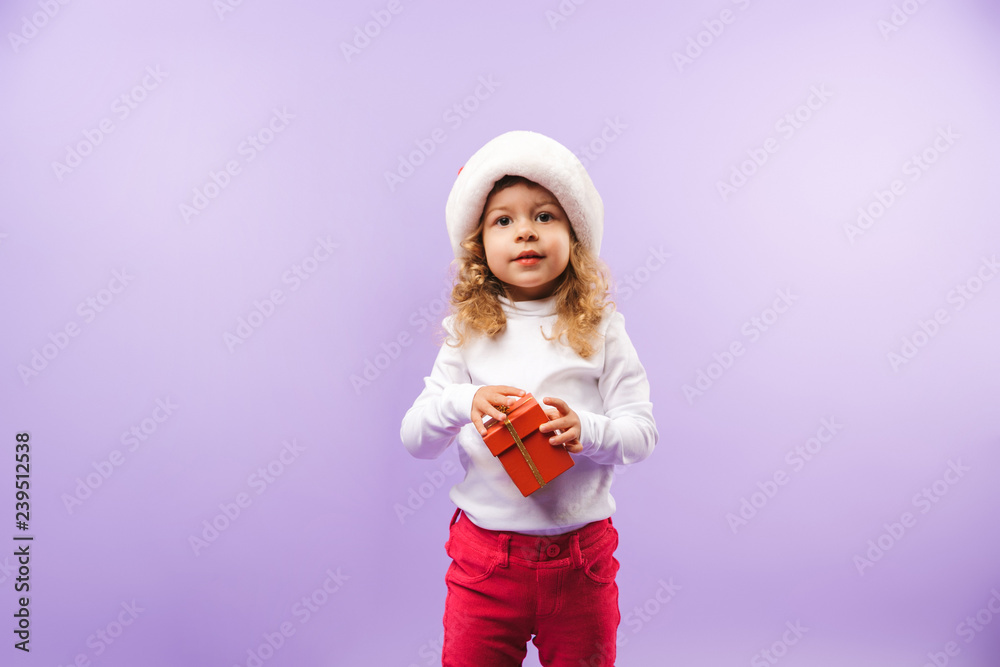 Cheerful little girl holding Christmas present box